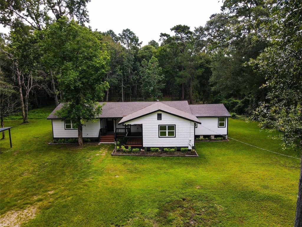 7728 White Rock Road Cleveland, TX 77328 - Photo 6 of 36 a house that is sitting in the grass with large trees