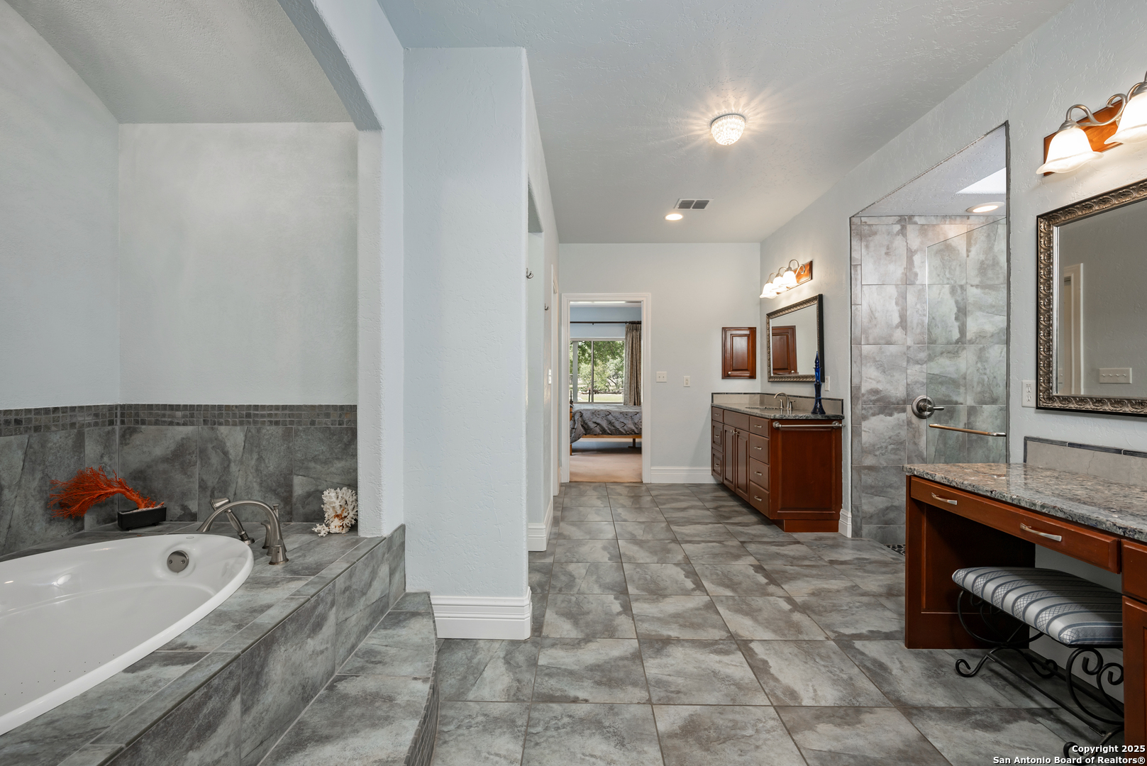 613 Saxet Trail Spring Branch, TX 78070 - Photo 14 of 41 a large bathroom with a tub a sink and mirror