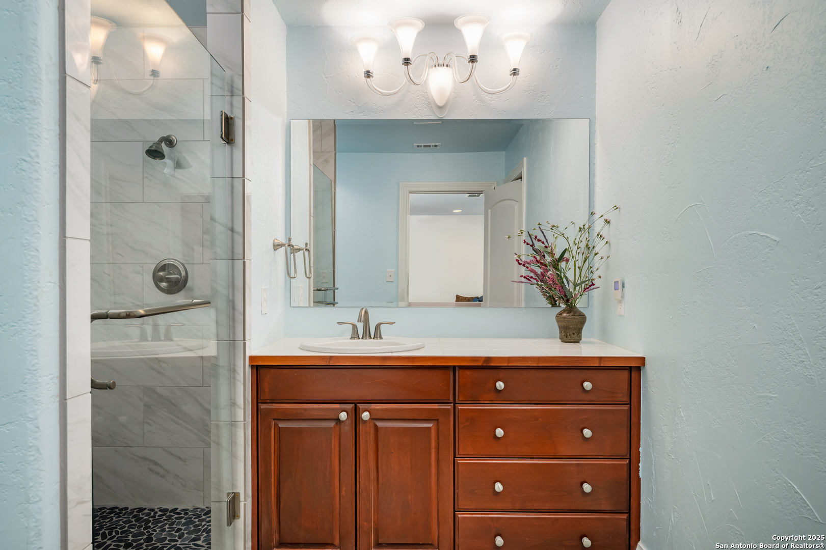 613 Saxet Trail Spring Branch, TX 78070 - Photo 20 of 41 a bathroom with a sink vanity granite shower and a mirror