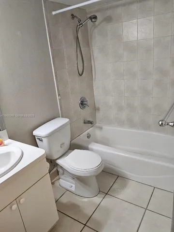 a white toilet sitting next to a bath tub and a shower