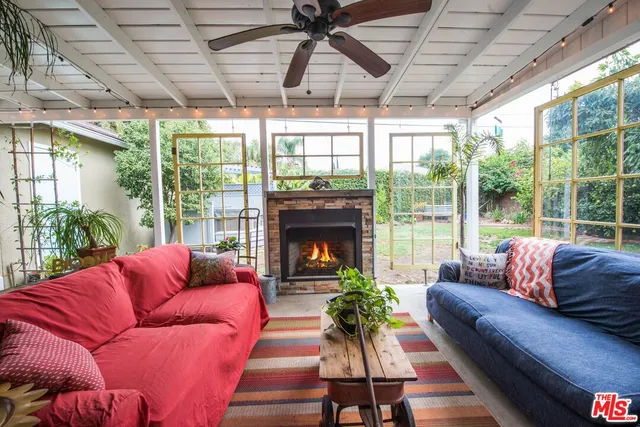 a living room with furniture a fire pit and a large window