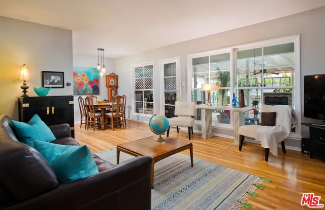 a living room with furniture and a flat screen tv with wooden floor