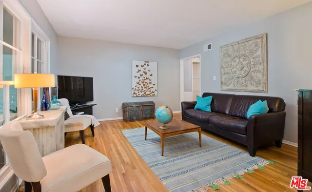 a living room with furniture a rug and a lamp