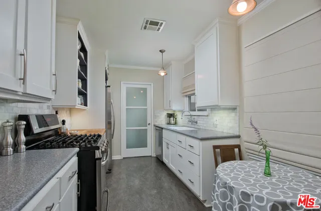 a kitchen with stainless steel appliances granite countertop a sink stove and cabinets