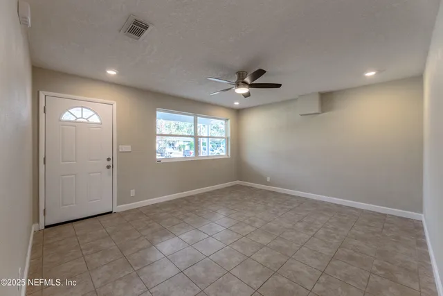 a view of a kitchen with a refrigerator a kitchen space and a window
