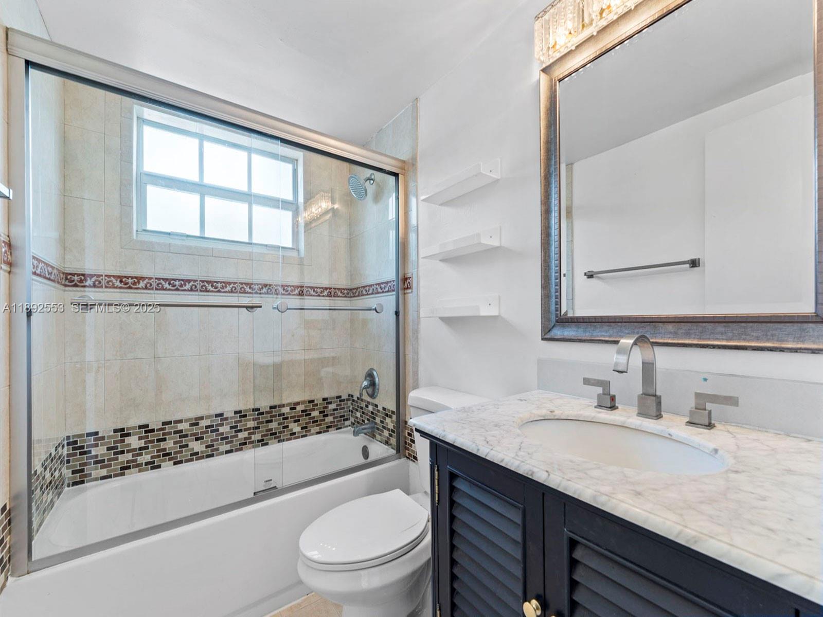 9100 Southwest 95th Avenue, Unit 9100 Miami, FL 33176 - Photo 17 of 37 a bathroom with a granite countertop sink a toilet a mirror and shower