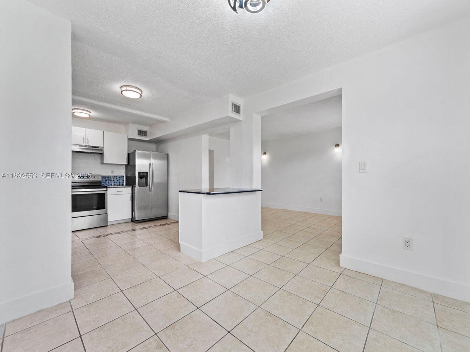 9100 Southwest 95th Avenue, Unit 9100 Miami, FL 33176 - Photo 7 of 37 a kitchen with stainless steel appliances a refrigerator and a stove top oven