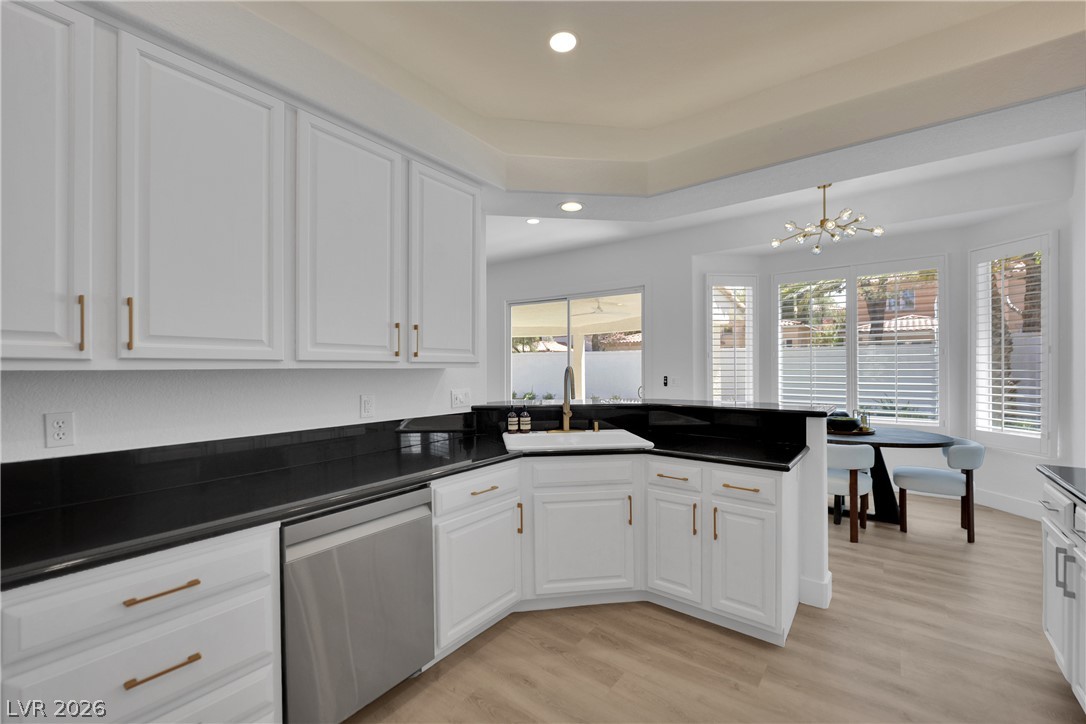 8981 Rivers Edge Drive Las Vegas, NV 89117 - Photo 22 of 69 A well-appointed kitchen features dark countertops, ample white cabinetry, and durable flooring, illuminated by recessed lighting.