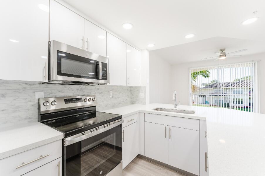 20889 St Andrews Boulevard Boca Raton, FL 33433 - Photo 4 of 5 a kitchen with a stove a sink and a microwave
