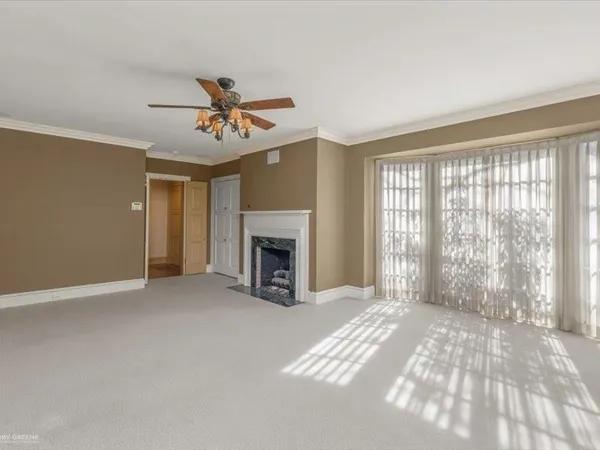 a view of an empty room with window and a kitchen