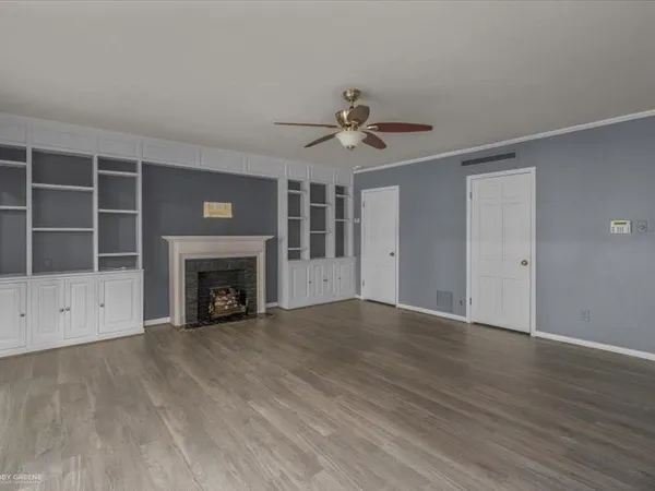 a view of an empty room with a fireplace and a window