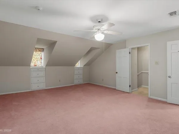a view of an empty room with a chandelier fan
