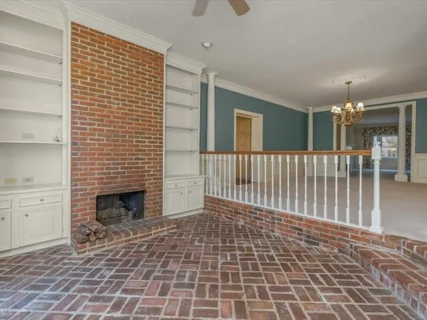 a view of empty room with stairs and a fireplace