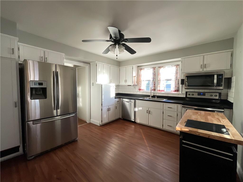 809 Locust Avenue Washington, PA 15301 - Photo 13 of 27 a kitchen with stainless steel appliances granite countertop a refrigerator a stove a sink dishwasher a microwave oven with cabinets and wooden floor