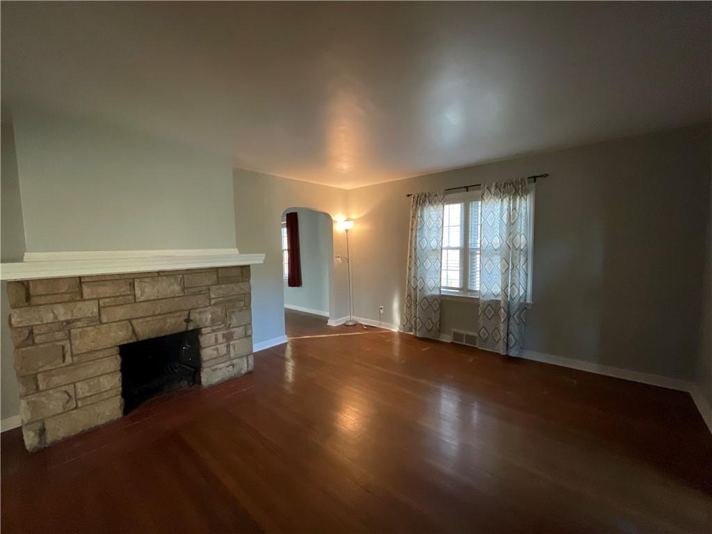 809 Locust Avenue Washington, PA 15301 - Photo 2 of 27 an empty room with wooden floor fireplace and windows
