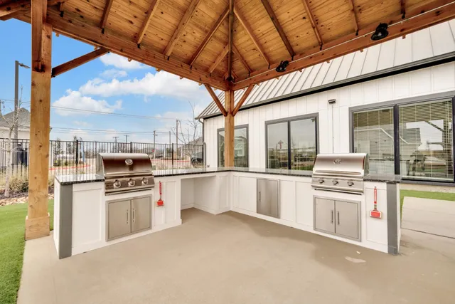 a large white kitchen with lots of counter space and stainless steel appliances