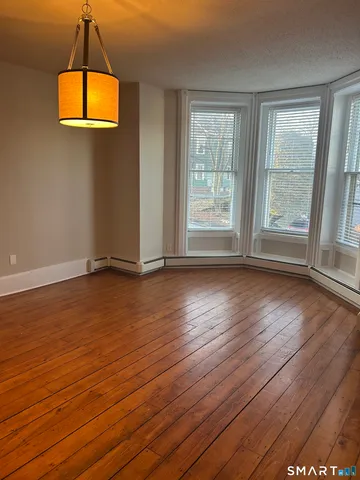 a view of a room with wooden floor and window