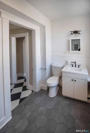 a bathroom with a toilet sink and mirror