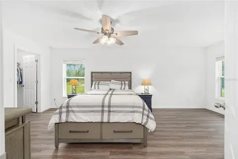 a bedroom with a bed window and a chandelier