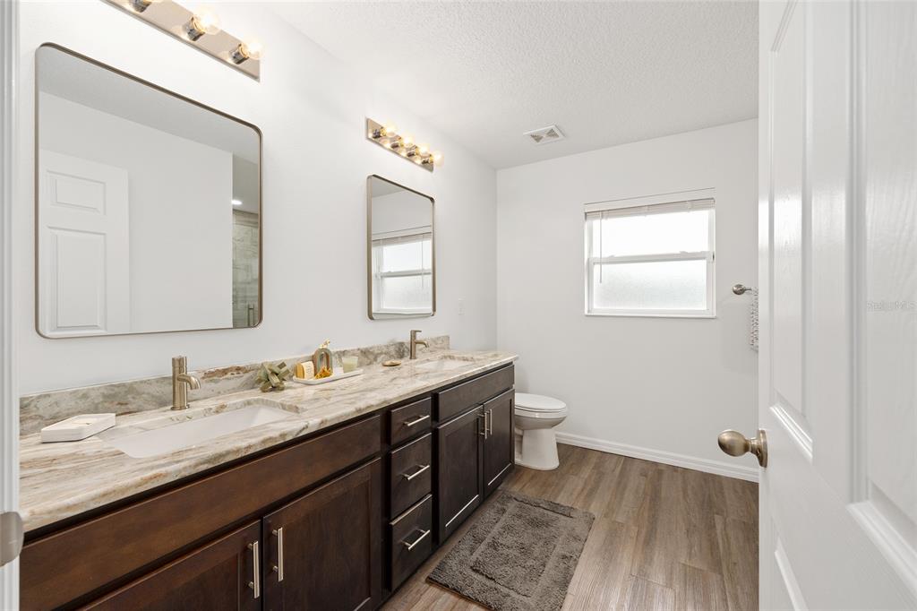 8381 North Wayside Avenue Dunnellon, FL 34433 - Photo 14 of 37 a bathroom with double vanity sinks a mirror and a toilet