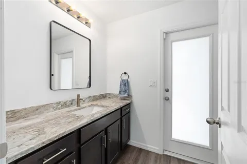 a bathroom with a granite countertop sink and a mirror