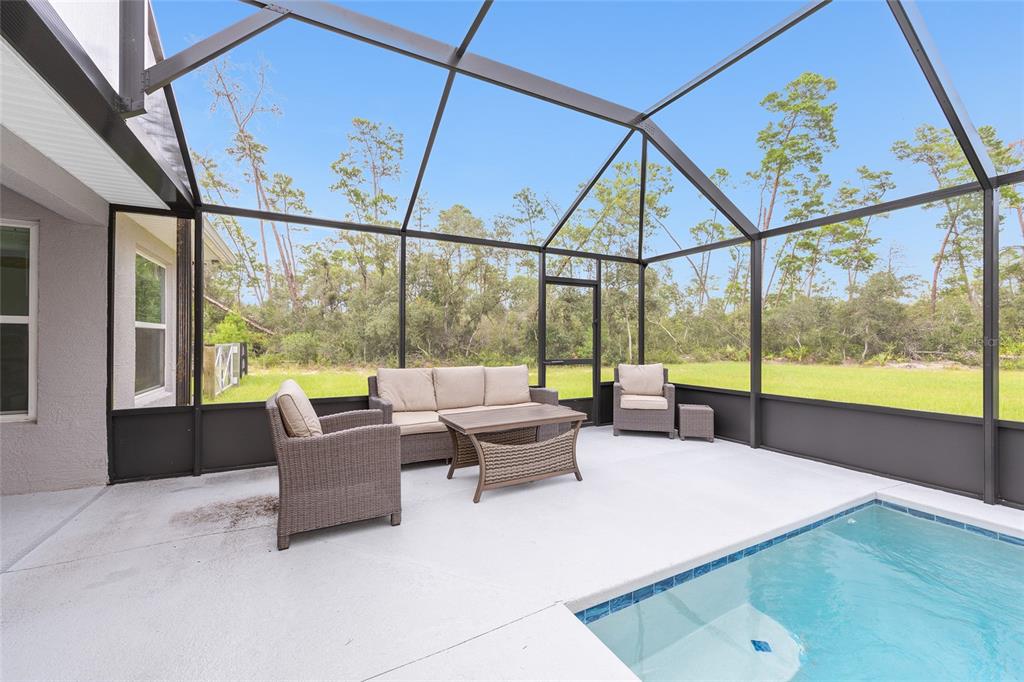 8381 North Wayside Avenue Dunnellon, FL 34433 - Photo 30 of 37 a living room with furniture and floor to ceiling windows
