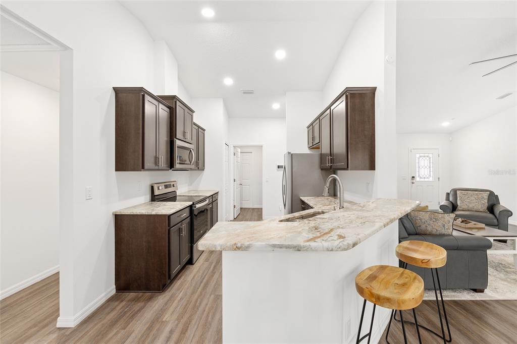 8381 North Wayside Avenue Dunnellon, FL 34433 - Photo 4 of 37 a kitchen with granite countertop counter space a sink appliances and cabinets