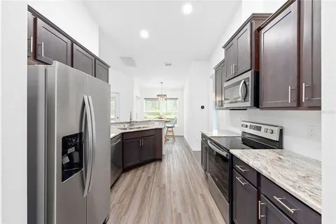 a kitchen with stainless steel appliances granite countertop a refrigerator a stove a sink and dishwasher