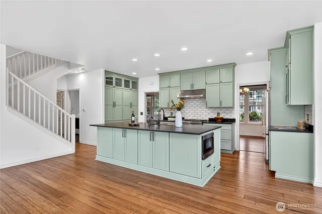 a kitchen with stainless steel appliances granite countertop a sink stove and wooden floor
