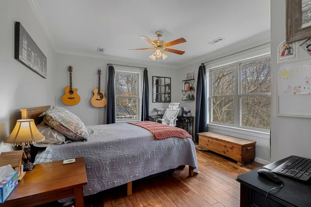 a bedroom with a bed and wooden floor