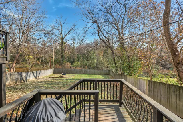 a view of a balcony with wooden floor and fence