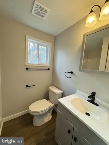 a bathroom with a toilet sink and mirror