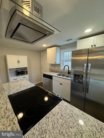 a kitchen with a stove a refrigerator and cabinets