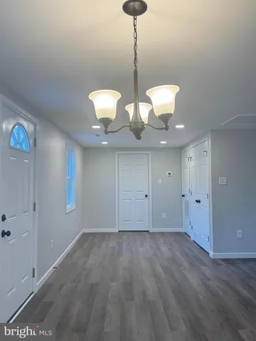 a view of a room with wooden floor and chandelier