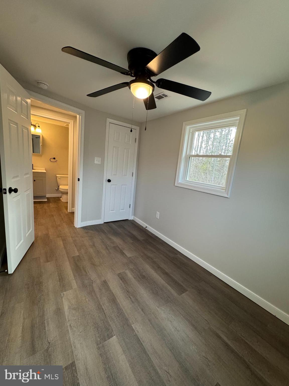 7178 Jericho Road Ruther Glen, VA 22546 - Photo 8 of 18 an empty room with wooden floor a ceiling fan and closet
