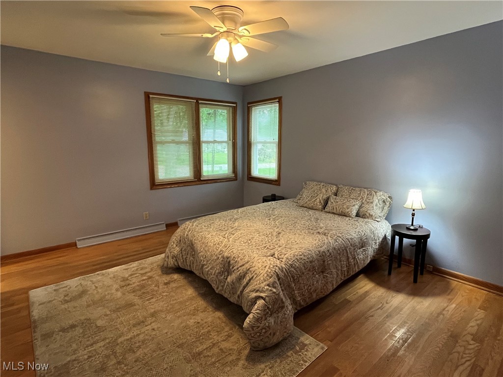 3252 Stanley Road Akron, OH 44333 - Photo 8 of 22 Primary bedroom featuring Pella windows, hard wood flooring with ceiling fan