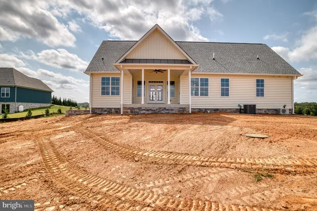 a view of a white house with a big yard and large trees