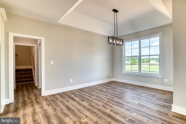 a view of a room with wooden floor and windows