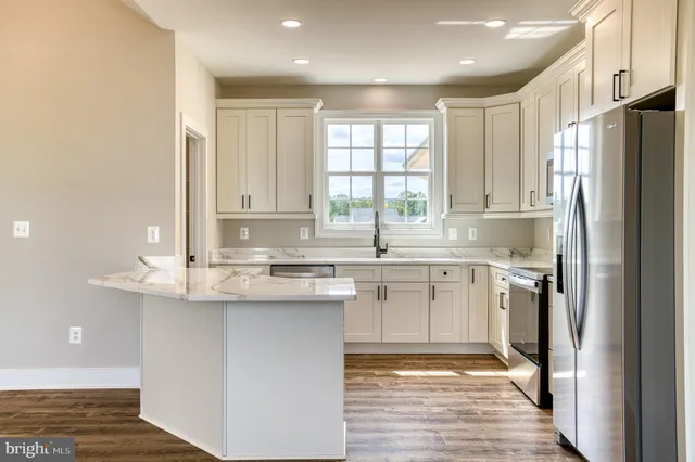 a kitchen with stainless steel appliances granite countertop a stove a sink and a refrigerator