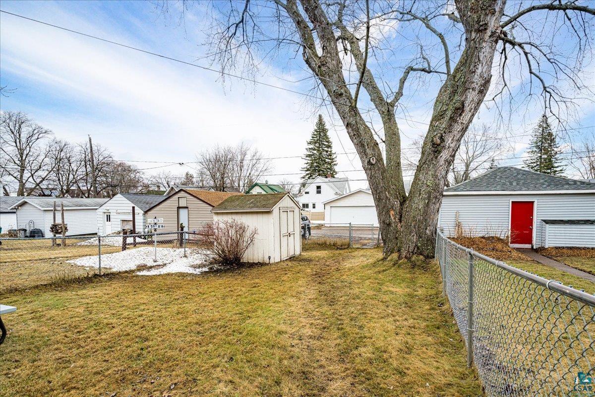 4316 West 6th Street Duluth, MN 55807 - Photo 10 of 39 Fenced backyard featuring a storage unit and a residential view