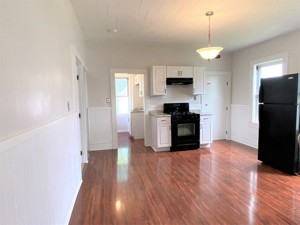 482 Snell Street Fall River, MA 02721 - Photo 3 of 41 a kitchen with a refrigerator and a stove top oven