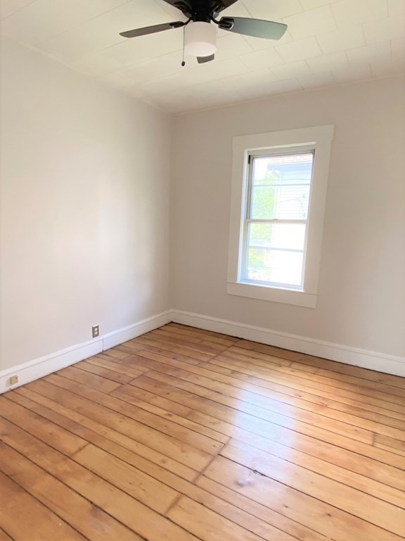 482 Snell Street Fall River, MA 02721 - Photo 7 of 41 an empty room with wooden floor fan and windows