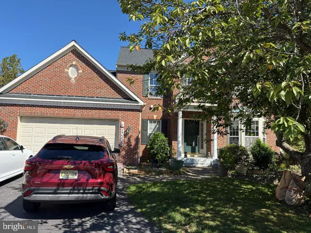 a view of a house with a small yard plants and a large tree