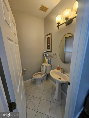 a bathroom with a toilet a sink and mirror