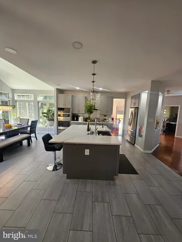 a spacious bedroom with a bed and a view of kitchen