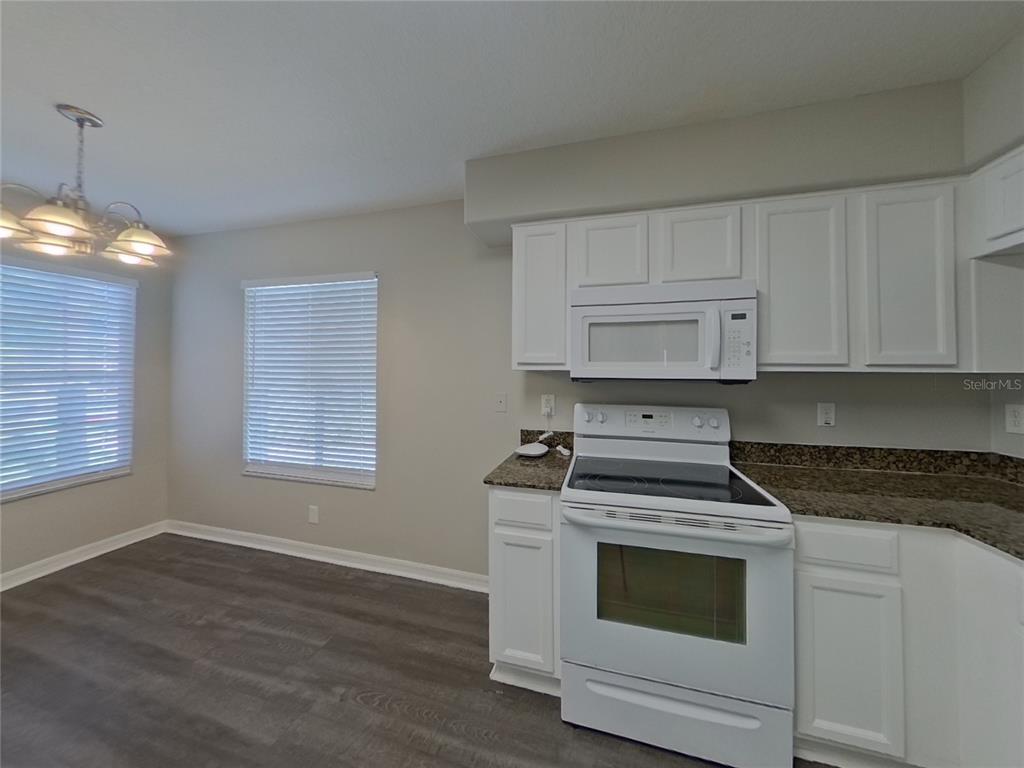 Undisclosed Address Wesley Chapel, FL 33545 - Photo 5 of 17 a kitchen with white cabinets and appliances