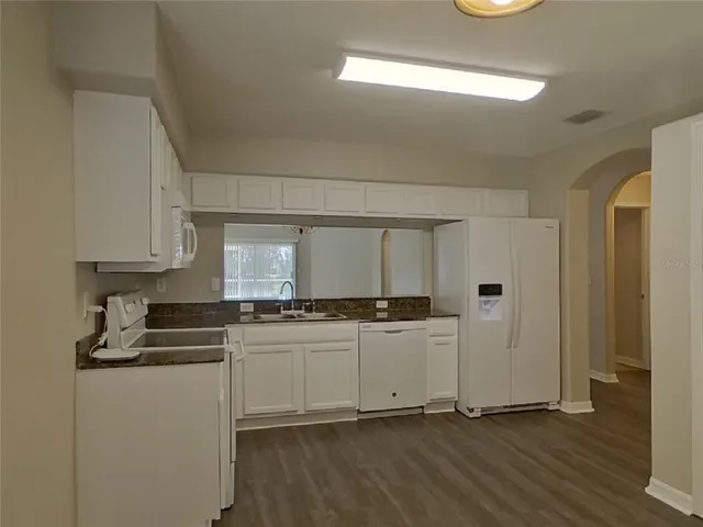 a kitchen with stainless steel appliances a stove a sink and white cabinets