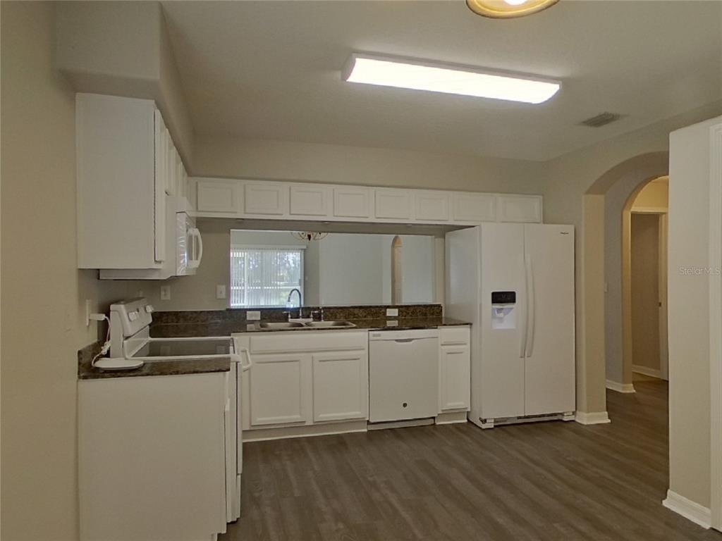 Undisclosed Address Wesley Chapel, FL 33545 - Photo 6 of 17 a kitchen with stainless steel appliances a stove a sink and white cabinets