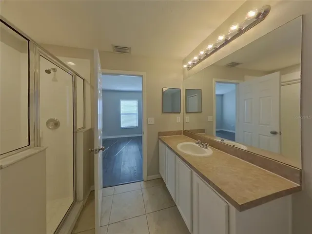 a bathroom with a granite countertop sink mirror and shower