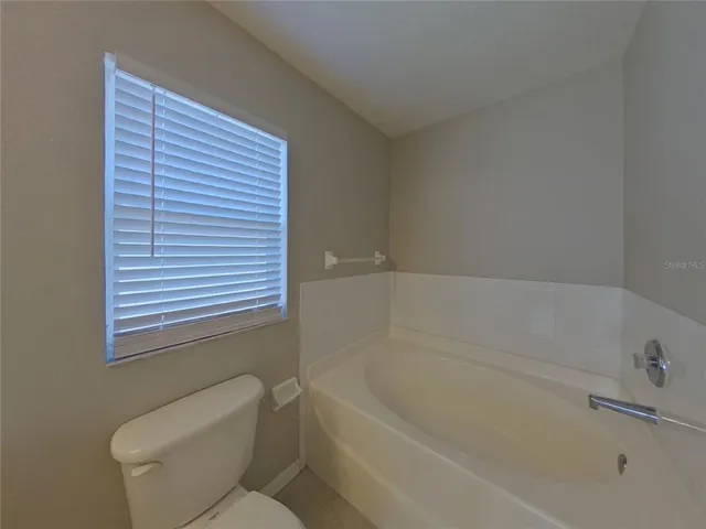 a bathroom with a toilet and bathtub